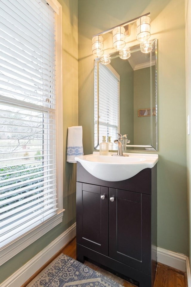 bathroom featuring vanity, crown molding, wood-type flooring, and a chandelier