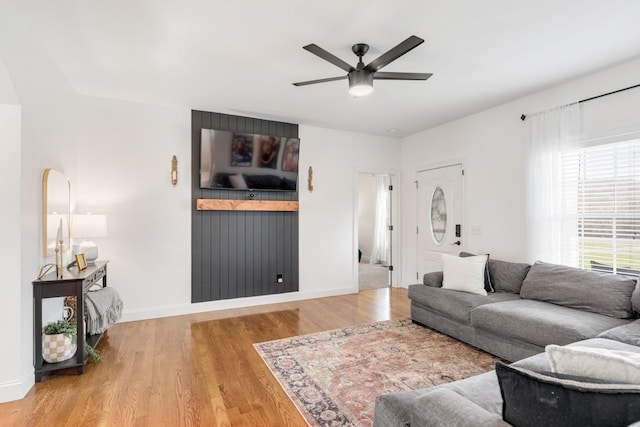 living room with light hardwood / wood-style flooring and ceiling fan