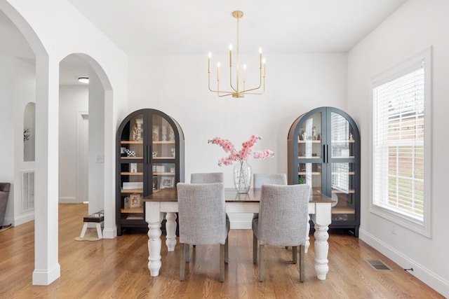 dining area featuring hardwood / wood-style floors and an inviting chandelier