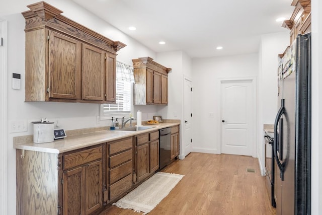 kitchen featuring dishwasher, refrigerator, light wood-type flooring, and sink