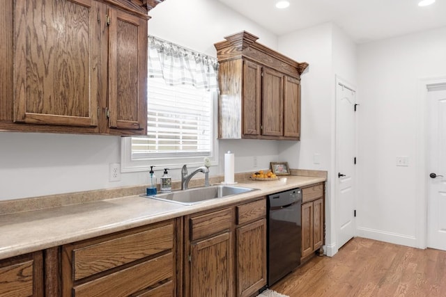 kitchen featuring dishwasher, light hardwood / wood-style floors, and sink