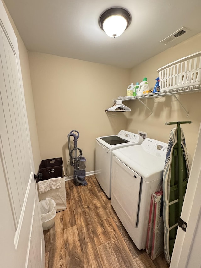 washroom with independent washer and dryer and dark hardwood / wood-style floors