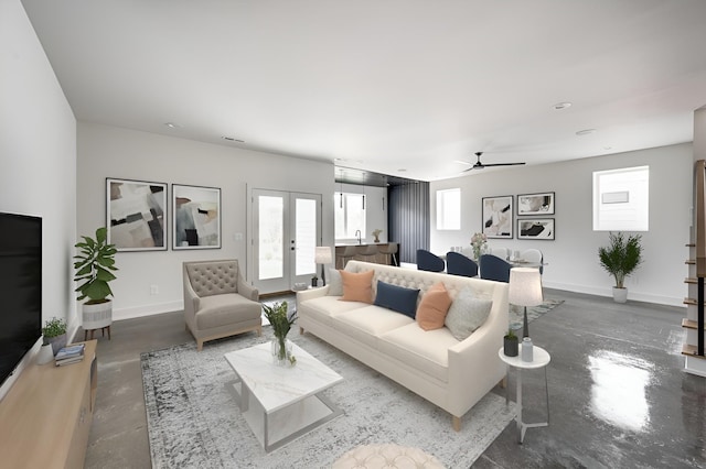 living room with french doors, concrete floors, ceiling fan, and a healthy amount of sunlight