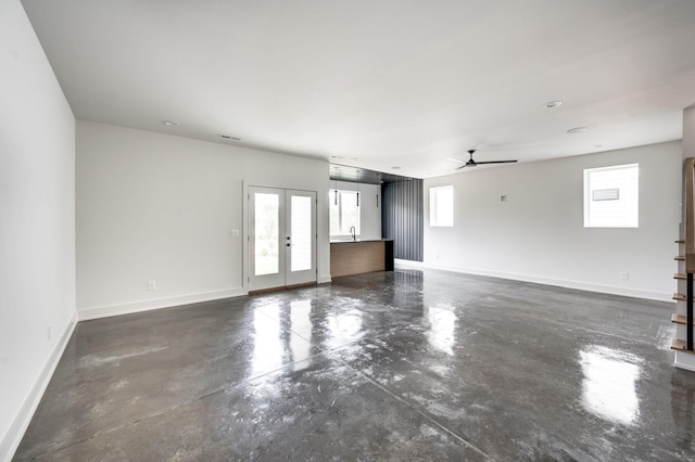 empty room featuring french doors, plenty of natural light, and ceiling fan