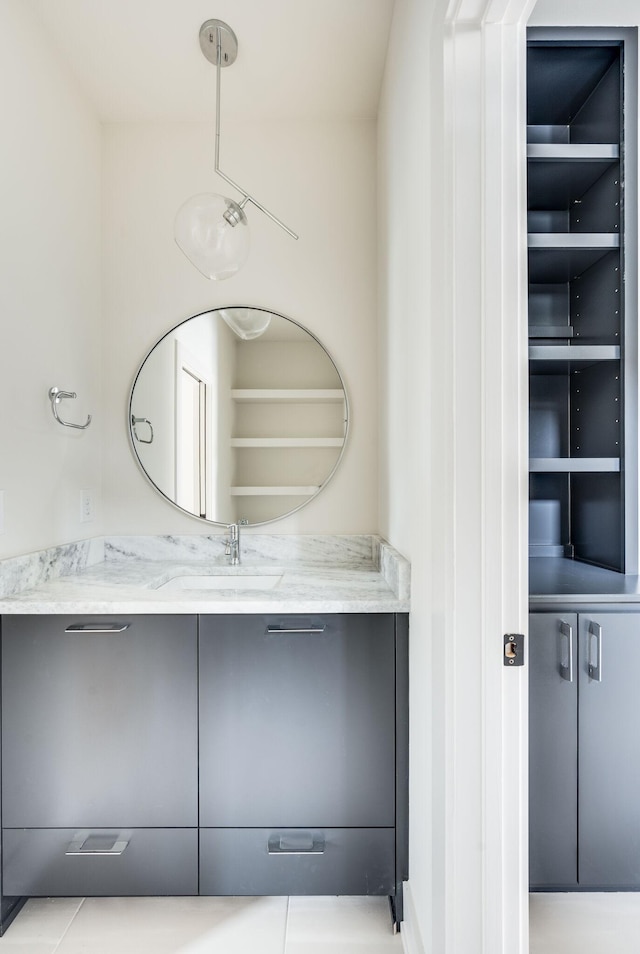 bathroom with built in shelves, tile patterned flooring, and vanity