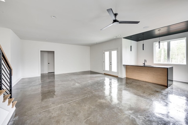 garage featuring ceiling fan, sink, and french doors