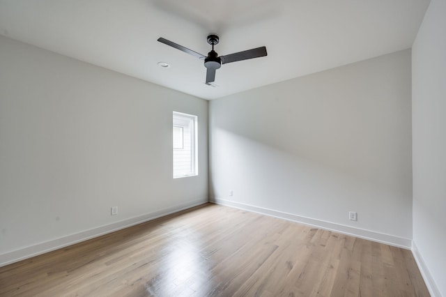 empty room with ceiling fan and light hardwood / wood-style flooring