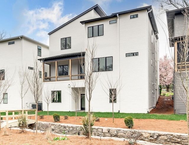 back of house featuring central AC unit and a balcony