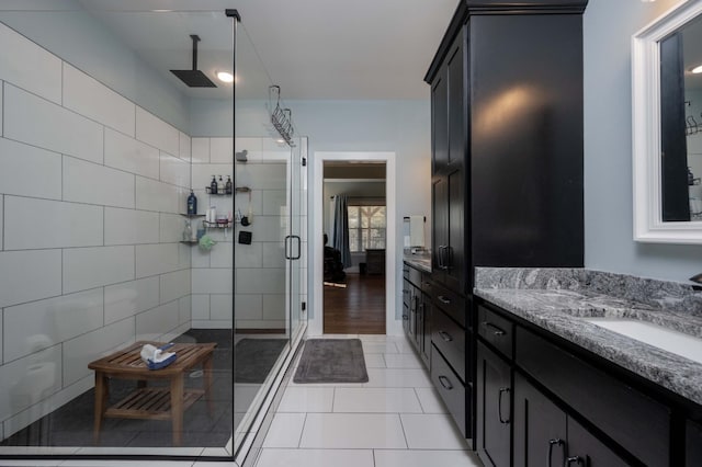 bathroom with tile patterned flooring, vanity, and a shower with shower door