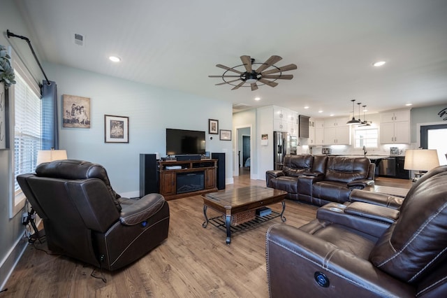 living room with ceiling fan and light wood-type flooring