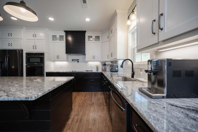 kitchen featuring dark wood-type flooring, sink, black appliances, pendant lighting, and white cabinetry