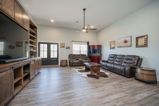 living room with ceiling fan, light hardwood / wood-style floors, and french doors