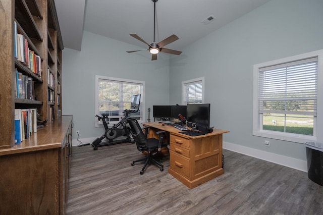 home office featuring ceiling fan, a healthy amount of sunlight, dark hardwood / wood-style flooring, and high vaulted ceiling