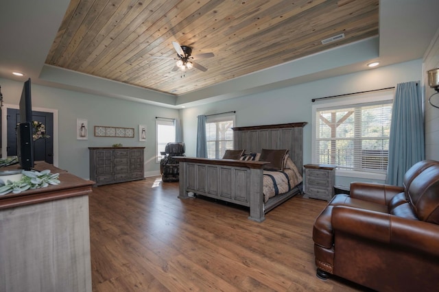 bedroom with a tray ceiling, multiple windows, ceiling fan, and wooden ceiling