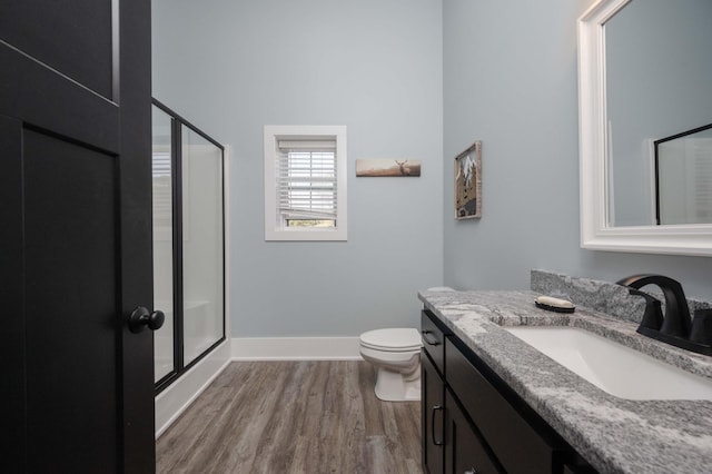 bathroom featuring hardwood / wood-style floors, vanity, toilet, and an enclosed shower