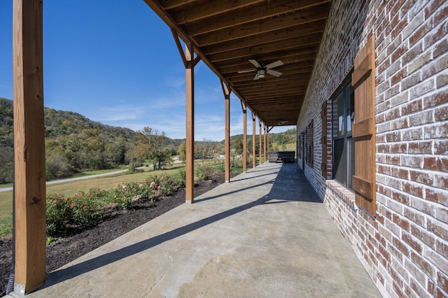 view of patio / terrace featuring ceiling fan and a mountain view