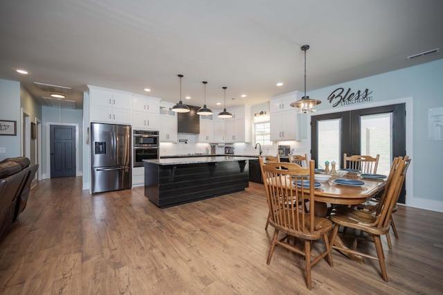 dining area featuring hardwood / wood-style floors and a healthy amount of sunlight