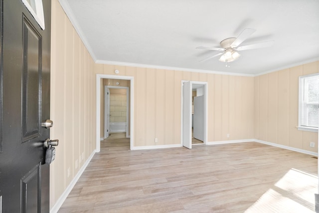 empty room with ceiling fan, ornamental molding, and light hardwood / wood-style flooring