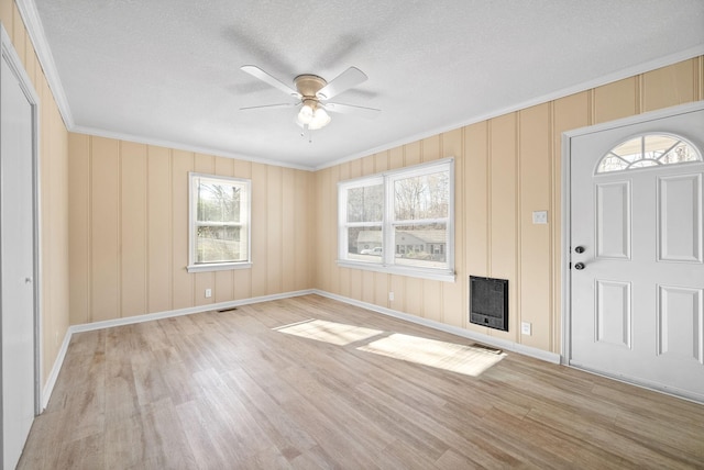 foyer entrance featuring plenty of natural light, light hardwood / wood-style floors, crown molding, and ceiling fan