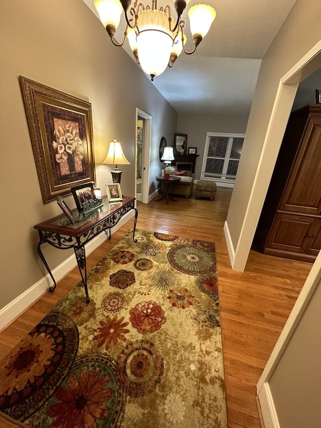 hall featuring light hardwood / wood-style flooring and an inviting chandelier