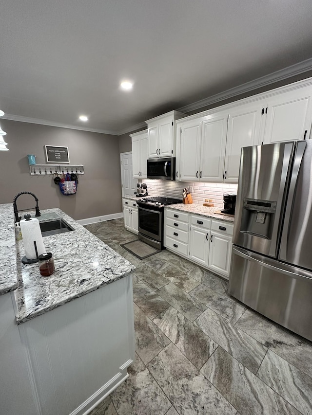 kitchen featuring sink, light stone countertops, appliances with stainless steel finishes, tasteful backsplash, and white cabinetry