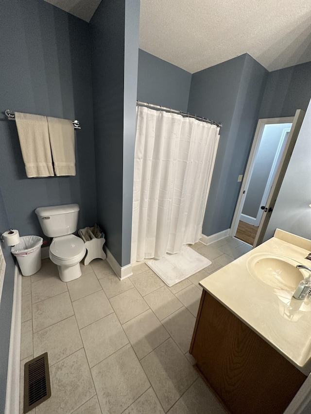 bathroom featuring tile patterned floors, vanity, toilet, and a textured ceiling