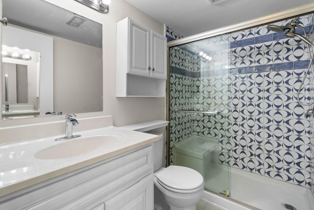 bathroom featuring vanity, an enclosed shower, and toilet