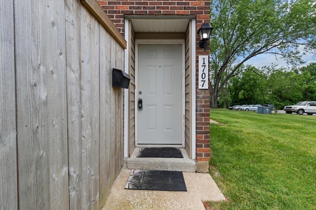 view of exterior entry featuring a yard