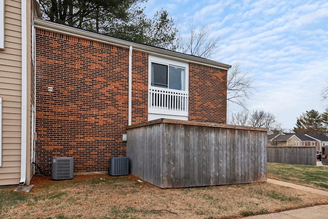 rear view of house featuring a yard and central AC unit