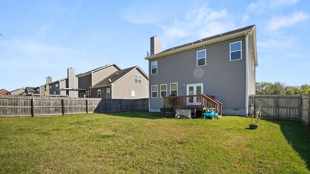 rear view of property featuring a deck and a yard