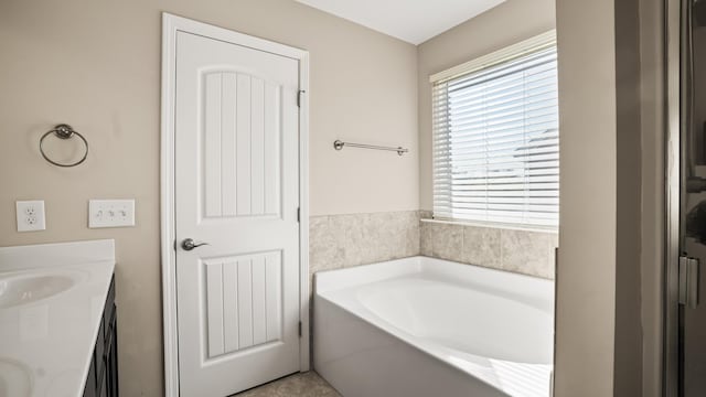 bathroom featuring a washtub, vanity, and tile patterned floors