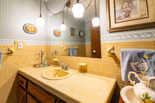 bathroom with wainscoting, vanity, and wallpapered walls