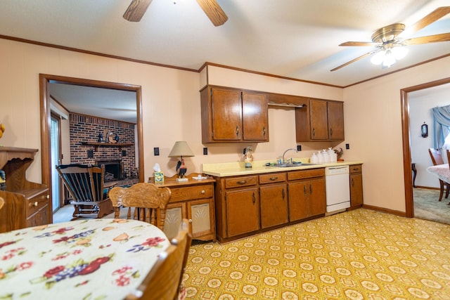 kitchen featuring ornamental molding, white dishwasher, light countertops, a brick fireplace, and a sink