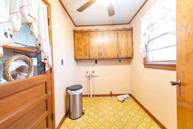 laundry room featuring baseboards, ceiling fan, cabinet space, and crown molding