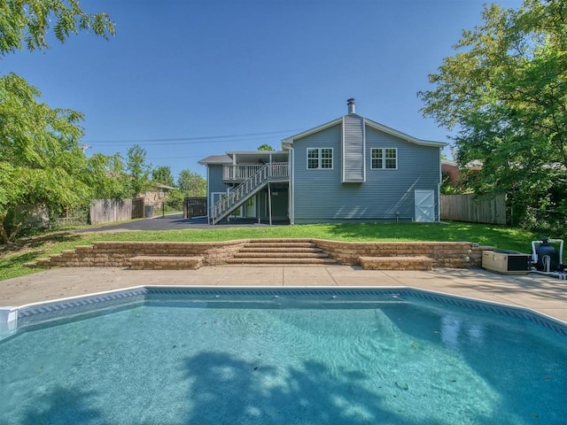 view of swimming pool featuring a patio area, a yard, and a deck