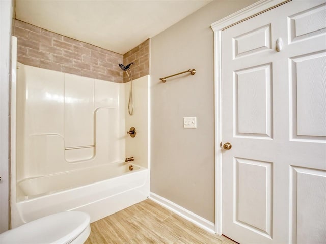 bathroom with shower / bathtub combination, toilet, and wood-type flooring