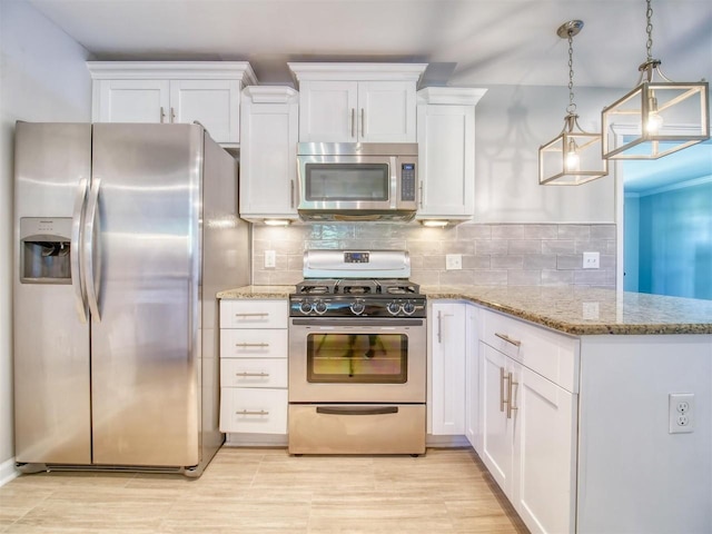 kitchen with tasteful backsplash, white cabinets, hanging light fixtures, and appliances with stainless steel finishes