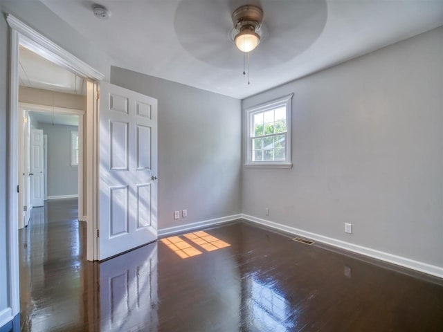 empty room featuring ceiling fan and dark hardwood / wood-style floors