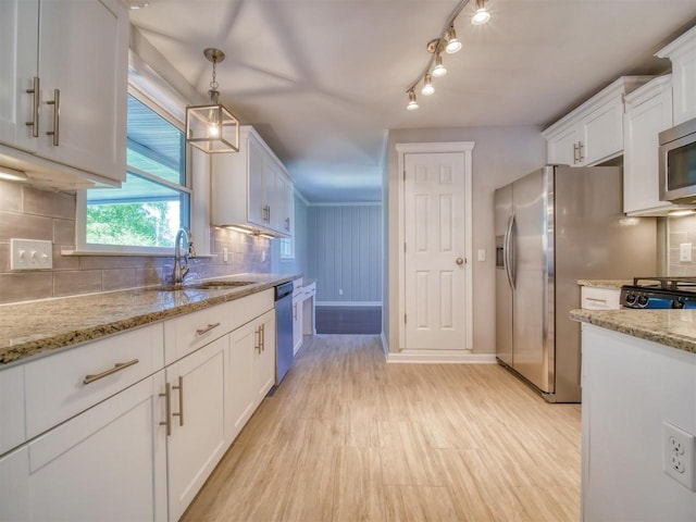 kitchen with white cabinets, decorative backsplash, sink, and hanging light fixtures