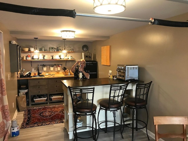 bar featuring wood-type flooring and hanging light fixtures