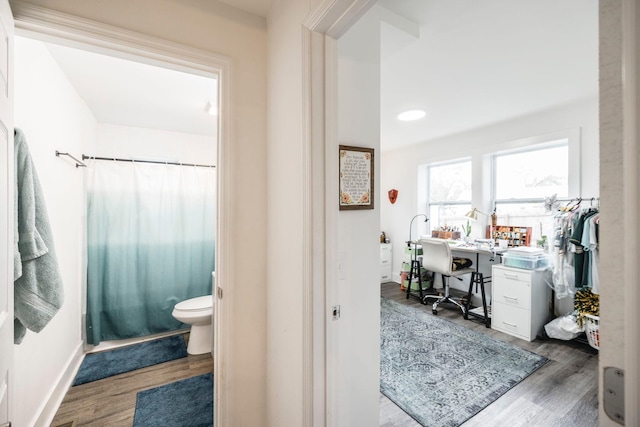 bathroom with hardwood / wood-style floors, toilet, and walk in shower