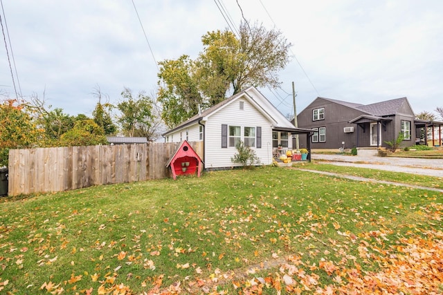 bungalow-style house with a front yard and fence