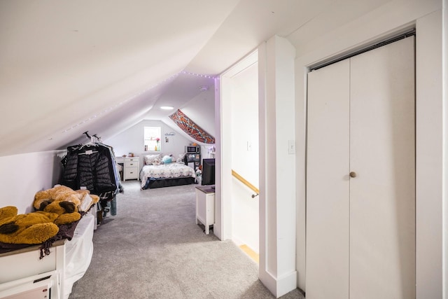 carpeted bedroom with vaulted ceiling and a closet