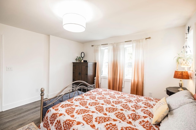 bedroom with dark hardwood / wood-style floors