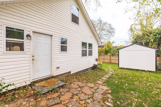 doorway to property with fence and a lawn