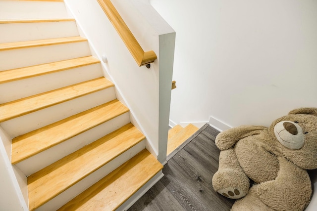 stairs with wood finished floors and baseboards