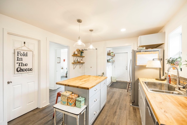 kitchen with butcher block counters, open shelves, dark wood-type flooring, and a sink