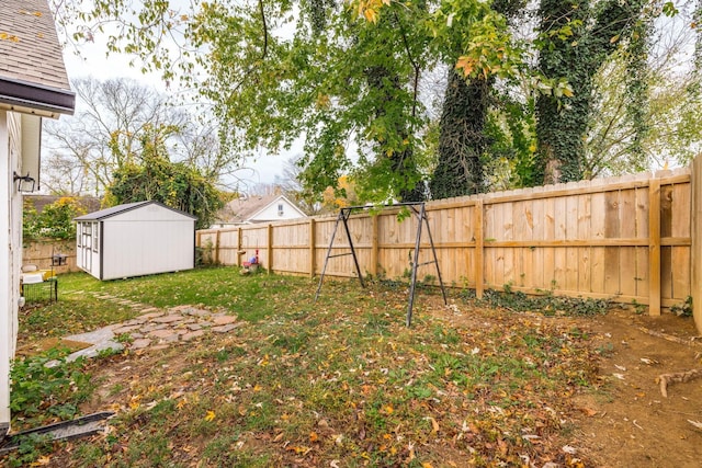 view of yard with an outbuilding, a storage unit, and a fenced backyard