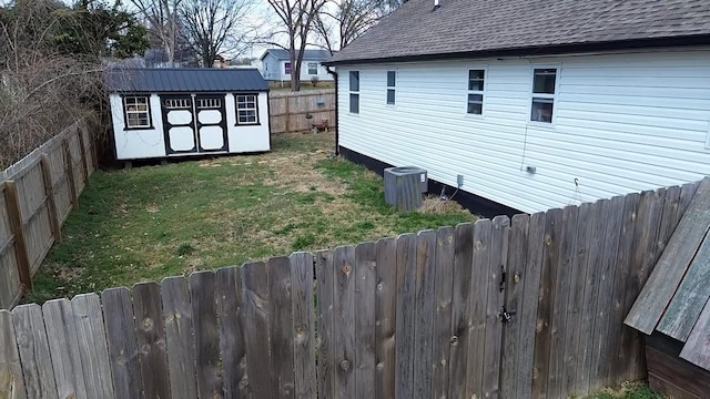 view of yard with an outbuilding, a storage unit, and a fenced backyard