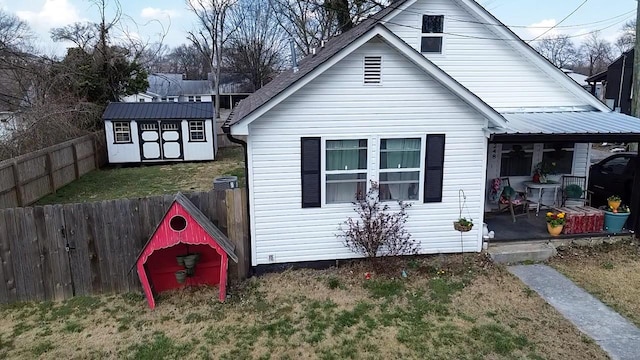 exterior space featuring an outbuilding, fence private yard, a shed, and metal roof